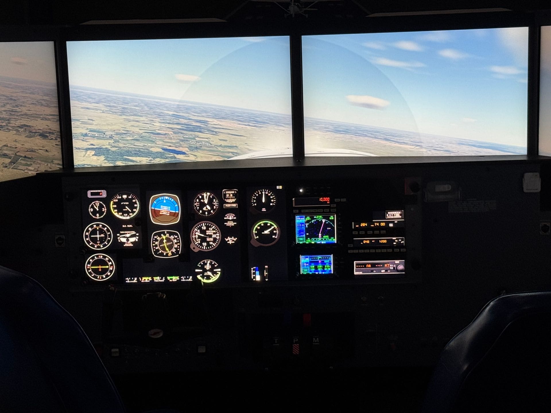 The wraparound visual screens of the Redbird LD simulator inside The Flight Lab™, showing a runway on approach from the cockpit view.